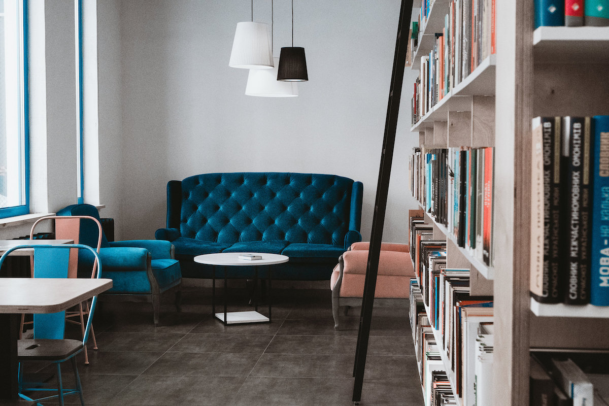 Room interior with blue sofa and bookcase