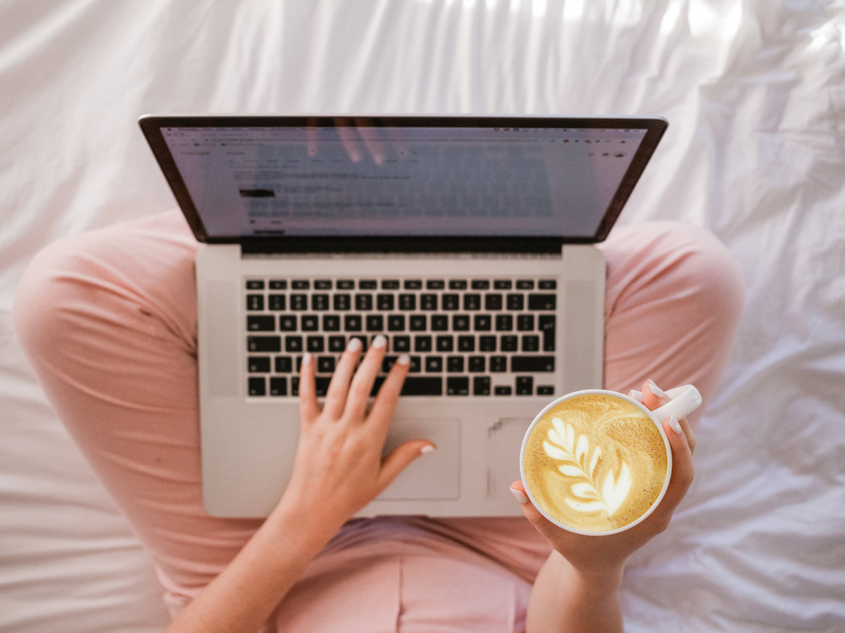 Woman holding coffee and laptop