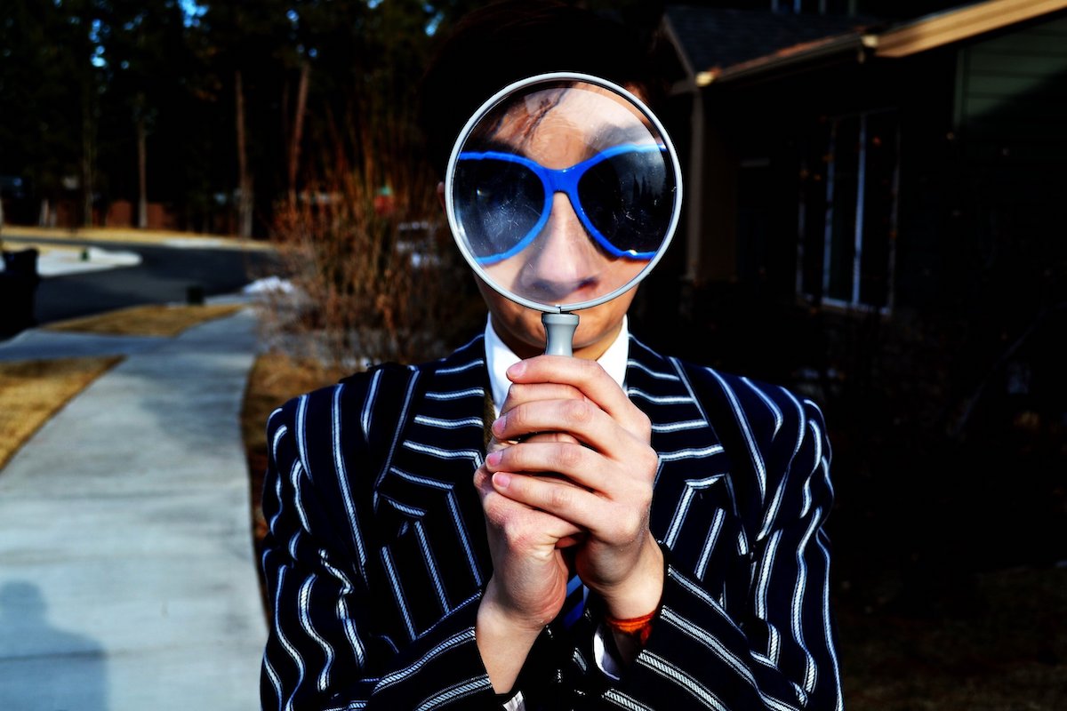 Woman with magnifying glass - how to find perfect customers online